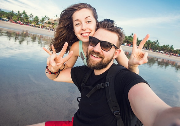 happy-young-virgo-man-and-scorpio-woman-in-love-having-fun-and-taking-selfie-portrait-on-beach-of-bali