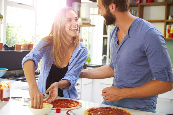 young-couple-making-pizza-in-kitchen-together