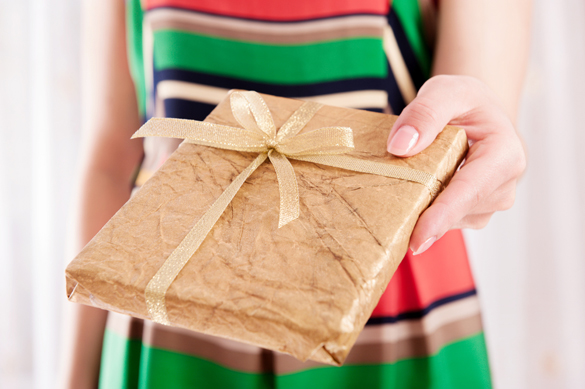 young-woman-holding-book-as-present-wrapped-in-golden-paper-for-virgo-man