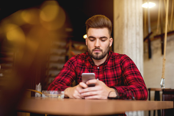 Lonely guy sitting at restaurant and texting - Why A Virgo Man Ignores Your Text Messages