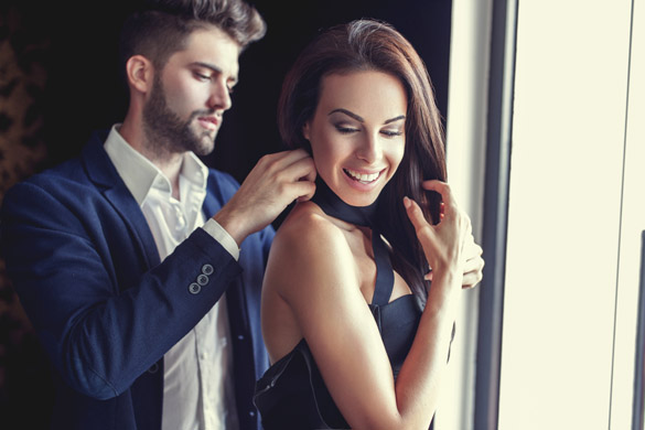 Stylish young man helps woman dressing up indoors - what attracts a Virgo man