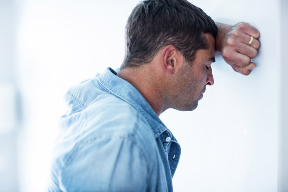 upset Virgo man leaning on wall with hand on forehead - What To Do When A Virgo Man Is Acting Hot And Cold