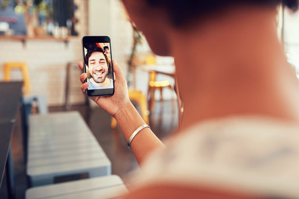 Virgo man and woman talking to each other through a videochat on a mobile phone - Is a Long Distance Relationship Possible with a Virgo Man